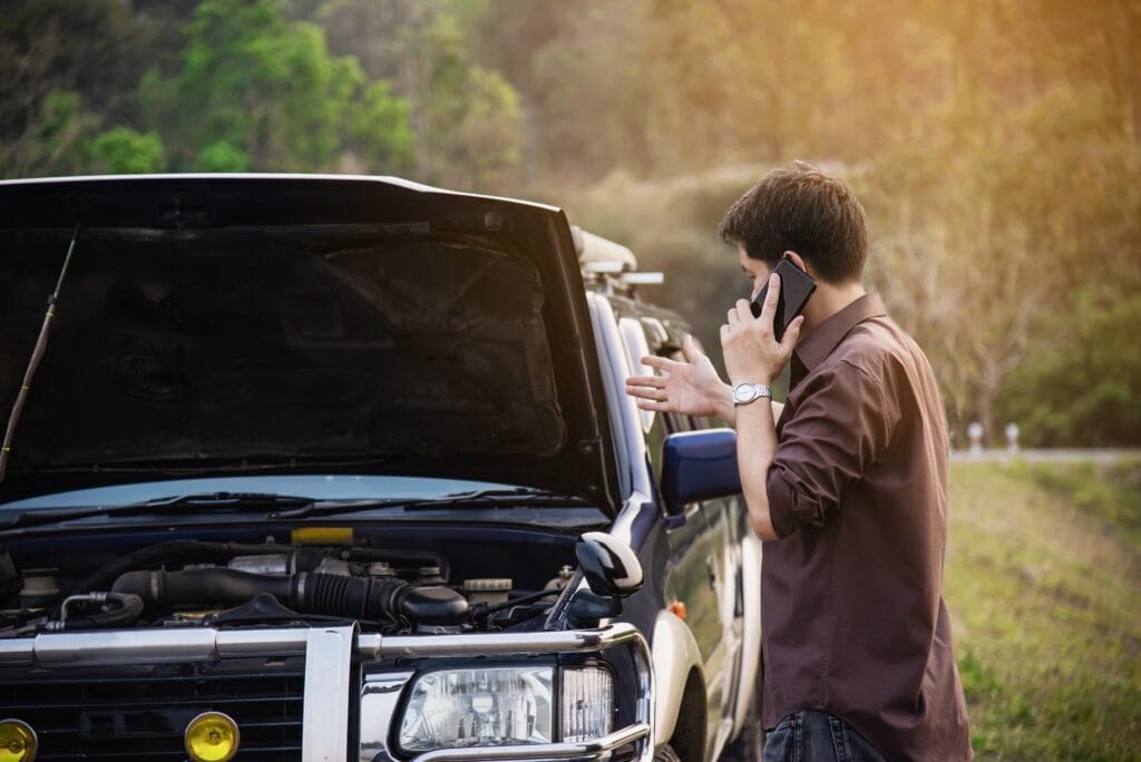 Man try to fix a car engine problem on a local road Chiang mai Thailand - people with car problem transportation concept